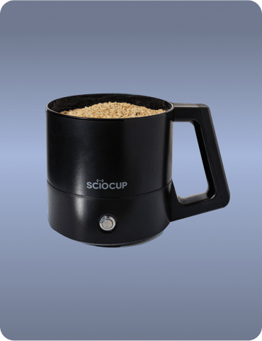 Black electric kitchen appliance with a handle, filled with ingredients. It has a button on the front and the brand name "Sciocap" visible.